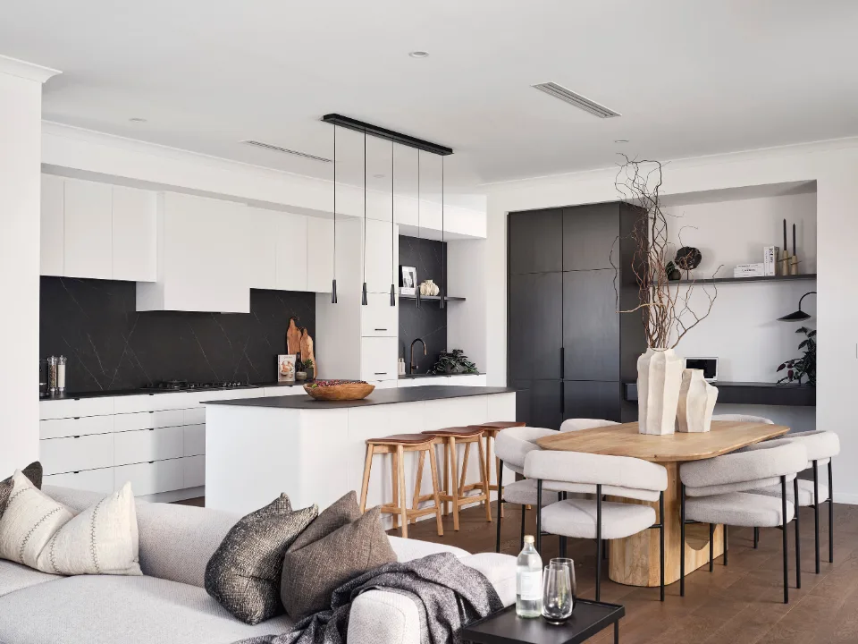 Modern open-plan kitchen and dining area with neutral tones and minimalist design.
