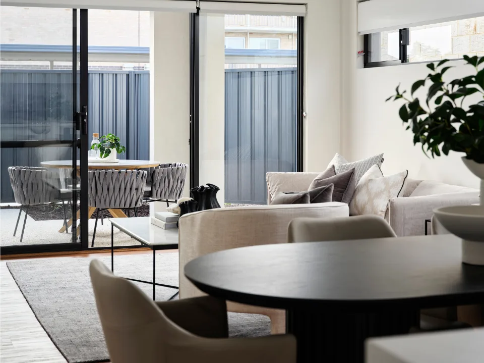Modern living room with cozy seating and dining area, emphasized by natural light and minimalist decor.