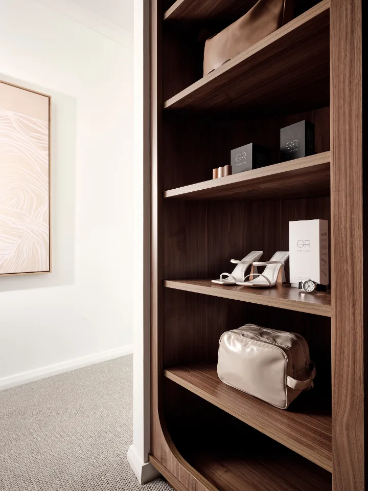 Luxurious wooden wardrobe interior showing stylish heels, a handbag, and watches for elegant and organized storage.