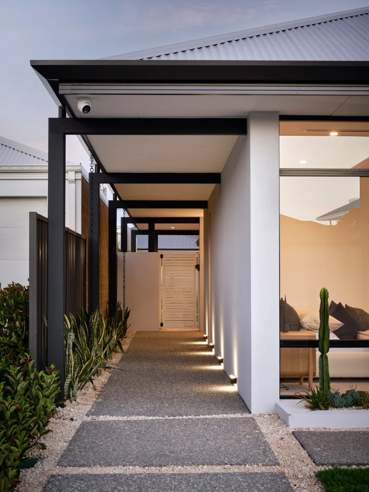 Modern home entrance with pathway lighting and sleek architectural design.