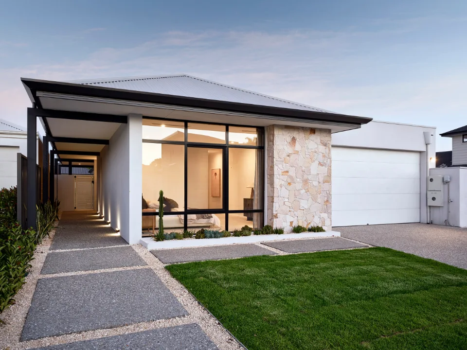 Modern single-story house exterior with stone facade and large windows.
