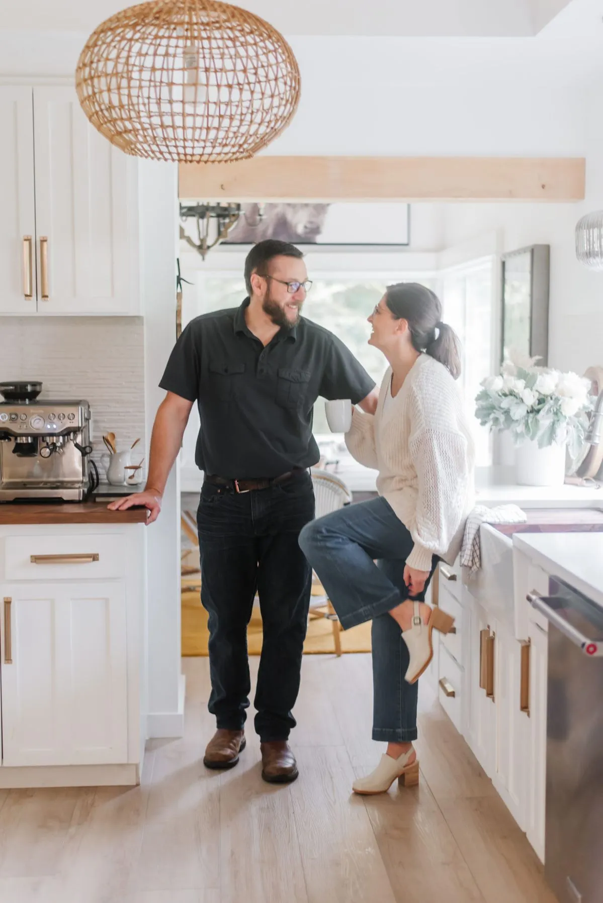 Couple enjoying a modern kitchen with coffee and conversation.