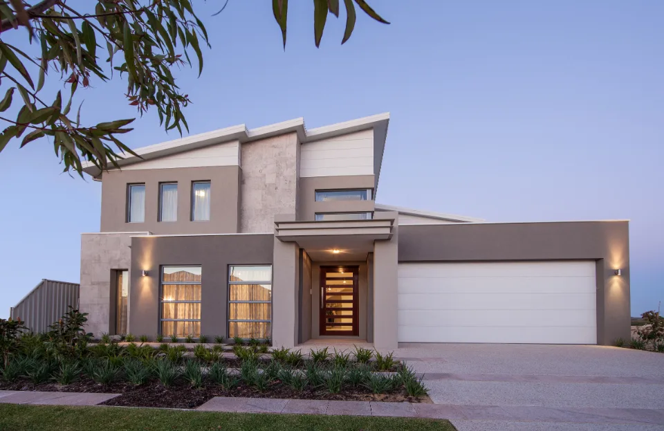Modern two-story house with large windows and a garage, exterior view at dusk.