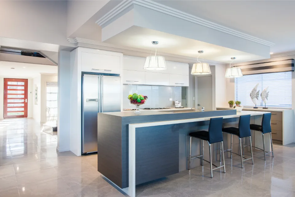 Modern kitchen with sleek island, pendant lighting, and stainless steel appliances.