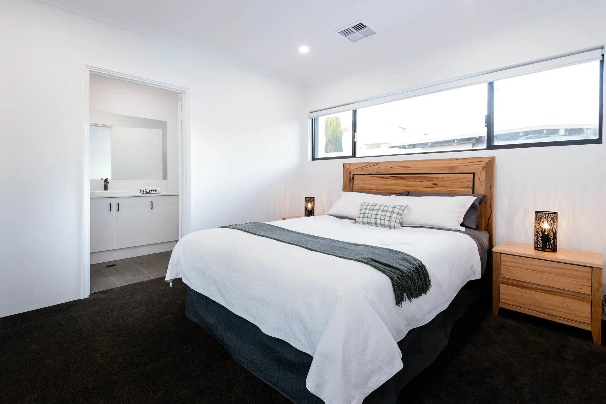 Contemporary bedroom with wooden bed frame and modern decor.