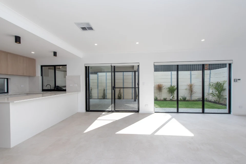 Modern open-plan living space with large windows and garden view.
