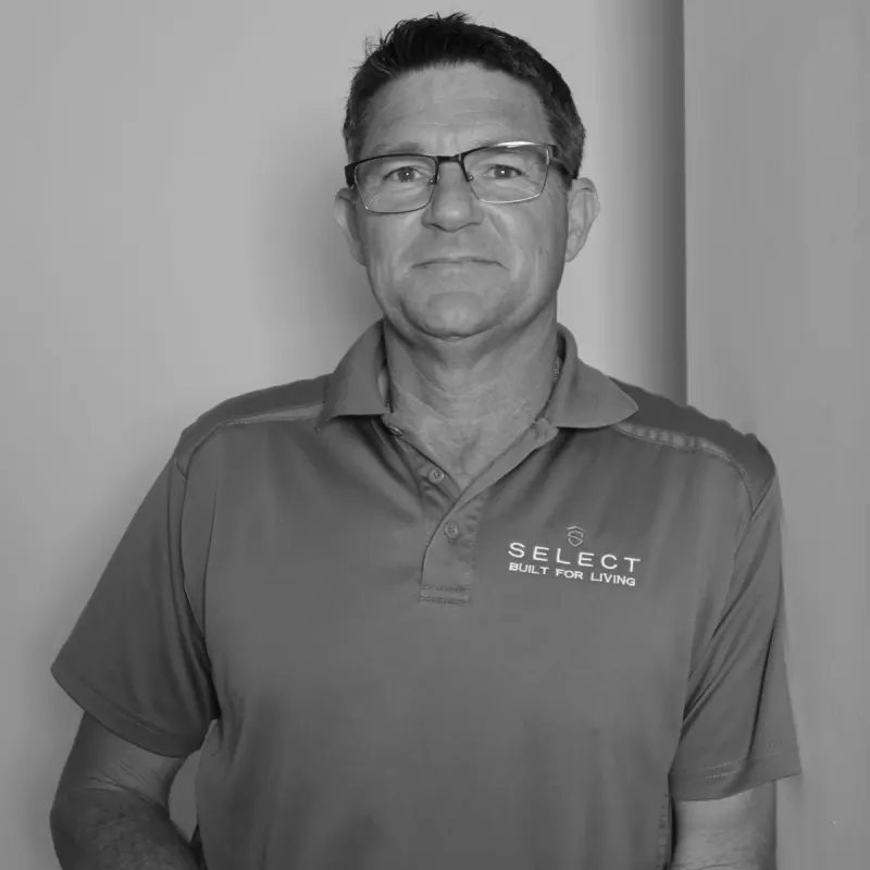 Andrew R, Site Manager. Professional black and white headshot, smiling with glasses in a branded polo shirt.
