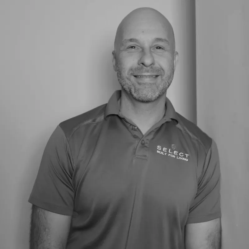 Davor T, Site Manager. Professional black and white headshot, with a shaved head and beard, in a branded polo shirt.