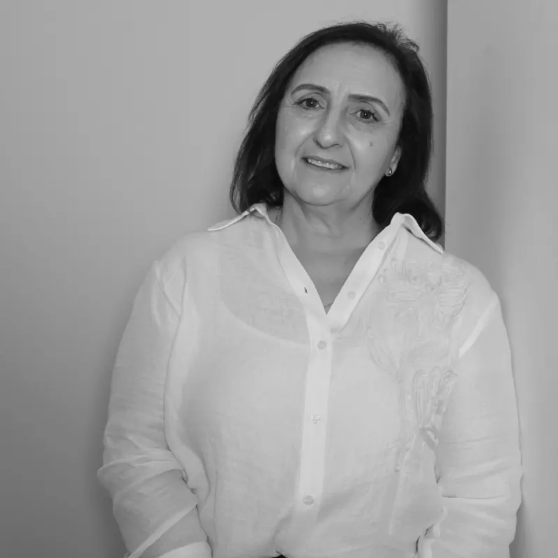 Nina B, Finance Manager. Professional black and white headshot, smiling in a white collared shirt.