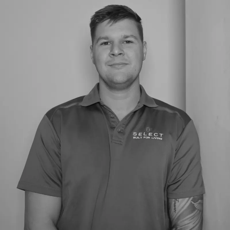 Riley HJ, Senior Scheduler. Professional black and white headshot, smiling in a branded polo shirt.