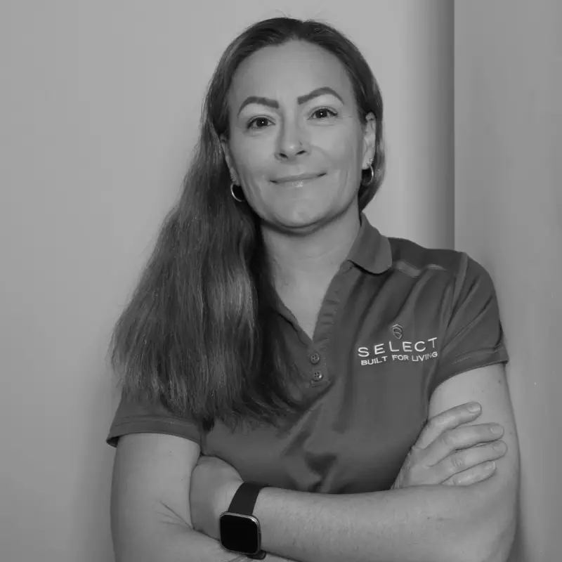 Tammy W, Wholesale Admin. Professional black and white headshot, arms crossed, smiling in a branded polo shirt.