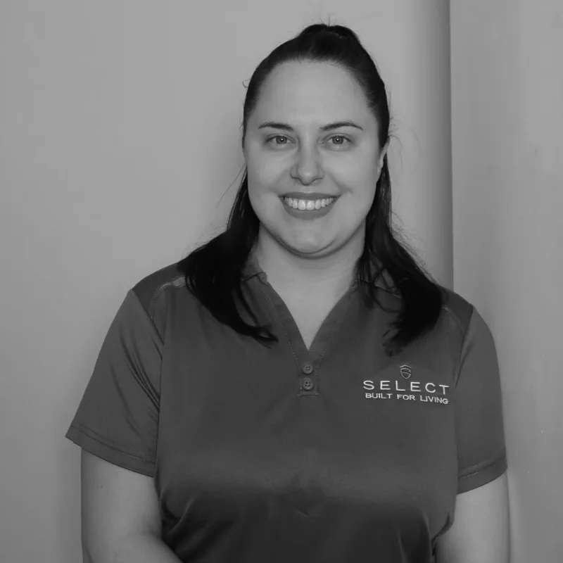 Tayla F, Wholesale Admin. Professional black and white headshot, smiling in a branded polo shirt.
